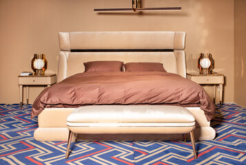 Bedroom interior in pastel brown tones with velvet and velor headboard.