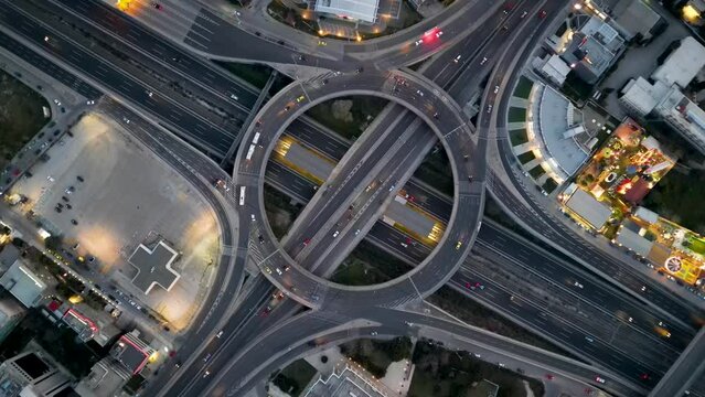 Aerial top view of a multilevel junction ring road as seen in Attiki Odos motorway interchange with car traffic in Marousi Attica, Athens, Greece, during dusk