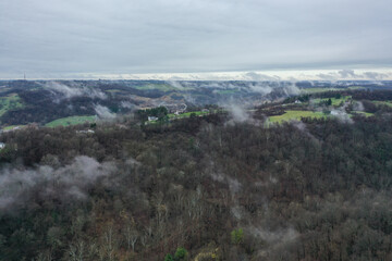 Fototapeta na wymiar Misty clouds over trees and houses