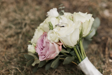 wedding bouquet of the bride with wedding rings