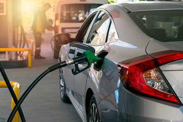 Refuel cars at the fuel pump. The driver hands, refuel and pump the car's gasoline with fuel at the...