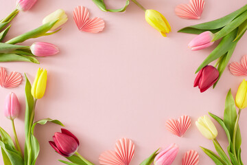 Obraz na płótnie Canvas Women's Day concept. Flat lay composition made of pink origami paper hearts colorful tulips flowers on pastel pink background with empty space in the middle