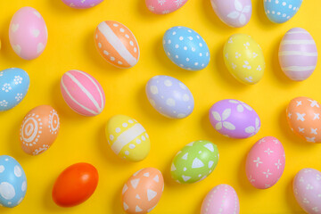 Happy easter holiday celebration concept. Group of painted colourful eggs decoration on a yellow background. Seasonal religion tradition design. Top view, flat lay, copy space.