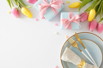 Mother's Day celebration concept. Top view photo of gift boxes with bows plate cutlery knife fork fabric napkin colorful hearts and yellow pink tulips on white background with empty space