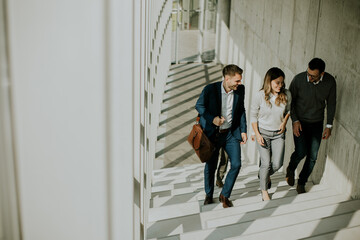 Group of corporate business professionals climbing at stairs in office corridor