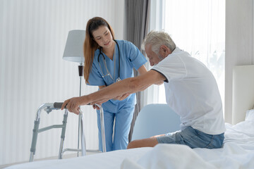 Fototapeta premium Elderly man talk to doctors and nurses in the hospital. senior male happy after receiving treatment and care and practice walk from a professional doctor. health care, physical therapy, nursing home