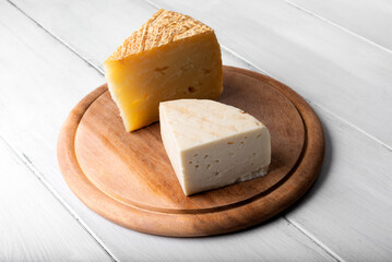 Pecorino fresco e pecorino stagionato su tagliere in legno, tipico formaggio italiano con latte di pecora 