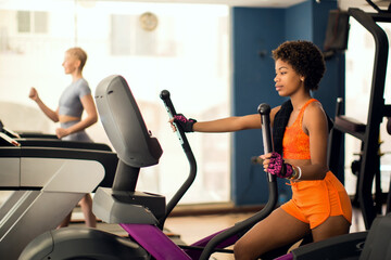 Fitness woman using elliptical medicine in the gym. Health and lifestyle concept