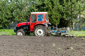 Modern tractor machinery plowing agricultural field meadow at farm at spring autumn. Farmer cultivating and make soil tillage before seeding plants and crops, nature countryside rural scene