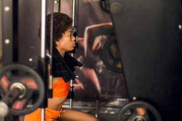 Fitness woman doing the barbell back squat using the power rack in a gym. Health and lifestyle...