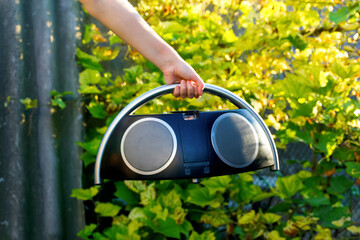Boombox. Defocus hand holding retro music recorder on nature. Retro outdated portable stereo...