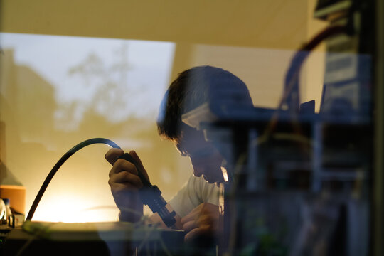 Repairman. Soldering station. Defocus technician repairing the smartphone's motherboard in the lab. Mobile phone, electronic, repairing, upgrade and technology. Components broken smartphone