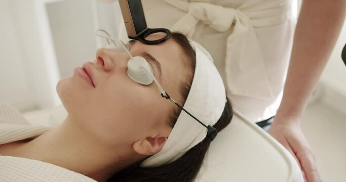Facial rejuvenation, aesthetic medicine is performing procedure. Beautician cosmetologist doing procedure fractional microneedle mesotherapy rejuvenation with laser technology. Beauty treatment.