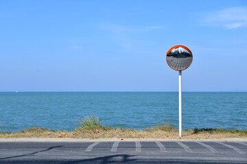 Curved glass on pillars on sandy beach