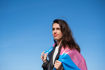 Transgender woman draped with the trans flag outdoors. LGTBIQ+ activism