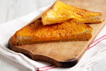 Homemade Inside-Out Grilled Cheese Sandwich on a rustic wooden board, low angle view. Close-up.