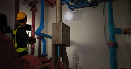 Professional engineer worker man in safety uniform holding flashlight checking maintenance the...