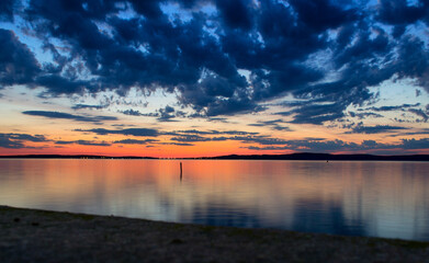 Fototapeta na wymiar Scenic view of lake against dramatic sky during sunset