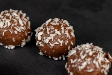 Obraz na płótnie Canvas Chocolate candies in the form of balls with milk coconut