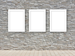 Three white frame templates on a decorative stone wall.