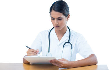 Doctor writing on clipboard while sitting at desk