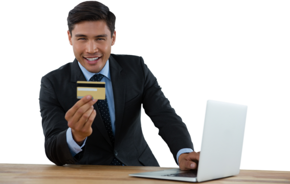 Portrait of businessman holding credit card while using laptop