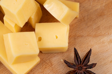 Yellow hard cheese sliced on a board