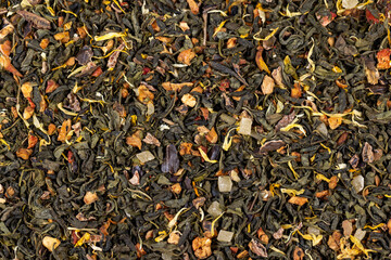 A large amount of dry green tea with pieces of fruit