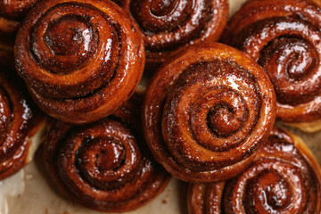 Freshly baked homemade Cinnamon rolls or Cinnamon buns on baking paper. Full frame shot
