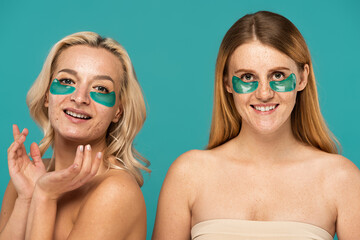 happy women with different skin conditions and patches under eyes smiling isolated on turquoise.