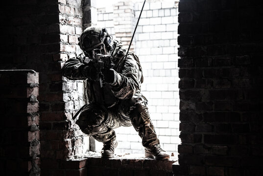 Black and white image of rappeller - police officer or soldier in tactical gear descending from a height to attack and fight. Tactical rappelling, anti-terror or counter terrorism operation in ruined