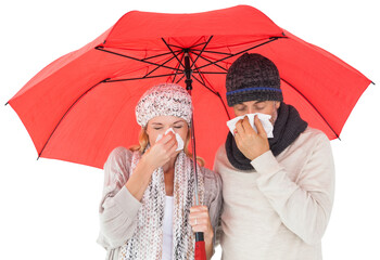 Ill couple sneezing in tissue while standing under umbrella
