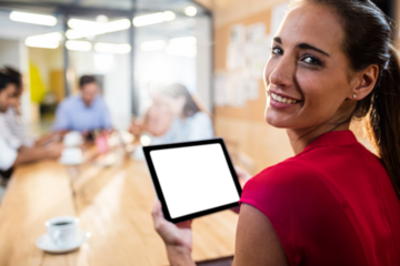 Businesswoman holding digital tablet while sitting at office