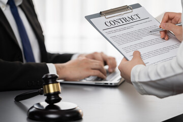 Focus contract paper on blur background of legal team or lawyer colleagues drafting legal documents...