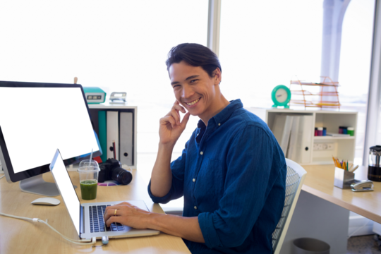Portrait of male executive working over laptop at desk