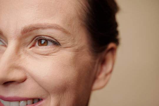 Face of smiling woman with forming eye wrinkles