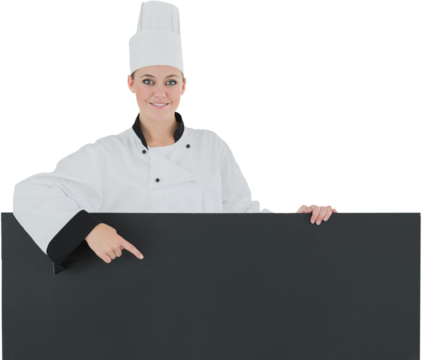 Happy female chef pointing at black billboard