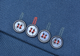 Buttons on a beautiful blue material of a sleeve on suit