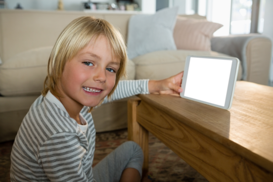Portrait of boy using digital tablet in living room