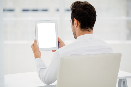 Businessman holding digital tablet while sitting on chair