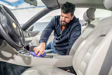 manual cleaning and polishing of luxury car interiors with a microfiber