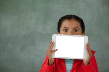 Girl holding digital tablet against chalk board in classroom