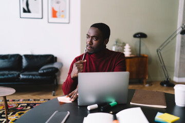 Pensive black man writing notes on paper
