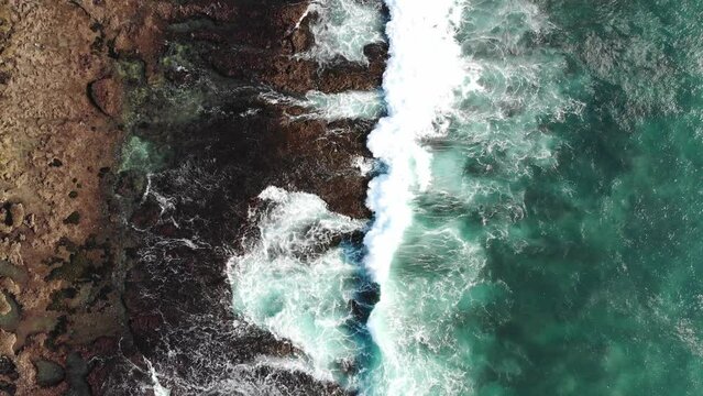 drone fly over rocky beach in Uluwatu Bali during golden hour