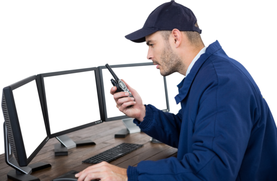Security officer talking on walkie talkie while observing computer monitor