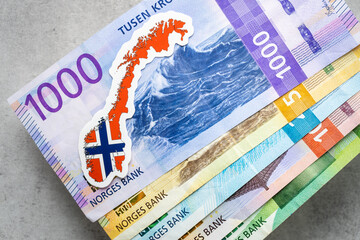 Norwegian money on a gray table top all banknotes, Norway flag, business and financial concept