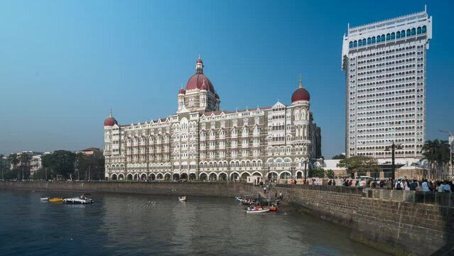 Time lapse view of tour boats in front of historic building Taj Mahal Palace built in 1903 in Mumbai, India. 