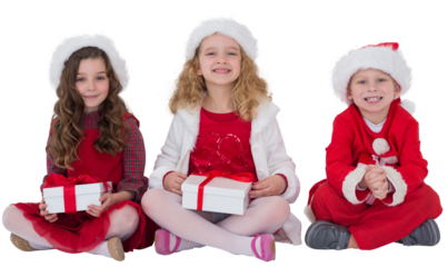 Festive little siblings smiling at camera holding gifts