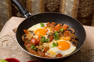 A set table and hot shakshuka in a frying pan.