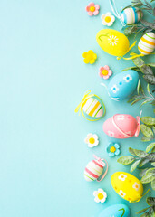 Easter background or greeting card on blue. Eggs, spring leaves, flowers and colored butterflies. Vertical with copy space